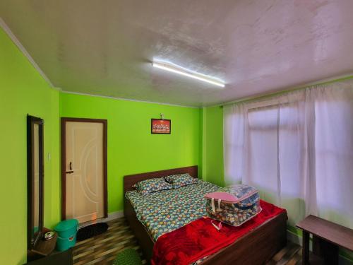 a green bedroom with a bed and a window at Neoravalley Homestay, Icche Gaon in Pedong