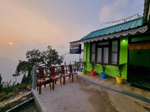 a group of chairs sitting outside of a building at Neoravalley Homestay, Icche Gaon in Pedong