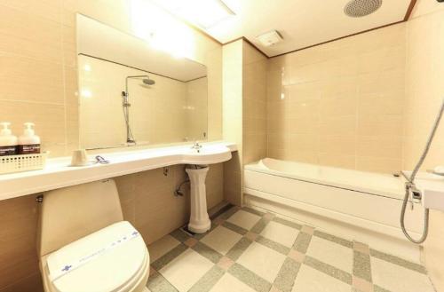 y baño con aseo, lavabo y bañera. en CF Motel en Jeju