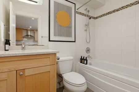 a bathroom with a toilet and a sink and a mirror at 2 Br basement suite Melbourne Av in North Vancouver