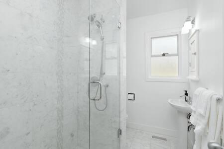 uma casa de banho com um chuveiro e um lavatório. em Spacious 3 bedroom property in North Vancouver em North Vancouver