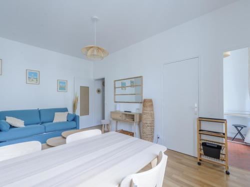 un salon avec un canapé bleu et une table dans l'établissement Studio Rénové à Deux Pas du Vieux Port avec Ascenseur - Idéal Pour 2! - FR-1-535-53, à La Rochelle