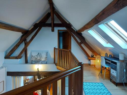 an attic room with skylights and a wooden staircase at Longère rénovée avec piscine, spa et hammam aux portes de Chartres, pour 12 personnes - FR-1-581-128 in Bailleau-lʼÉvêque