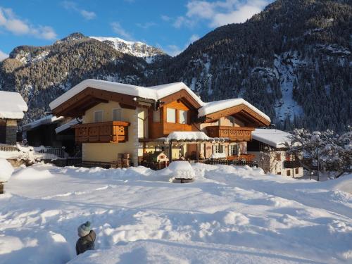 a house covered in snow in front of a mountain at Residence Rodolon Appartamenti in Campestrin