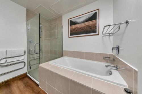 a bathroom with a bath tub and a shower at The Sunset Suite in Auckland