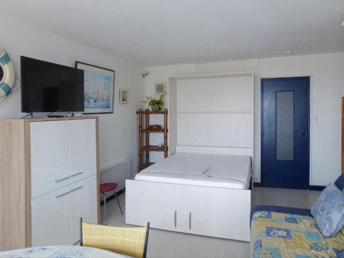 - une petite chambre avec un lit et une télévision dans l'établissement Location Studio Spacieux - Proche Plage et Commerces - Animaux Admis - FR-1-323-416, à Saint-Jean-de-Monts
