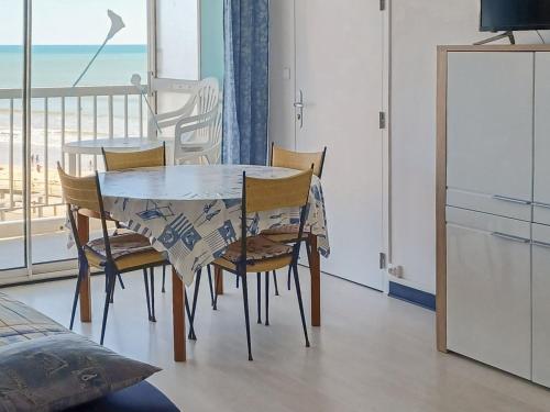 - une table à manger et des chaises avec vue sur la plage dans l'établissement Location Studio Spacieux - Proche Plage et Commerces - Animaux Admis - FR-1-323-416, à Saint-Jean-de-Monts