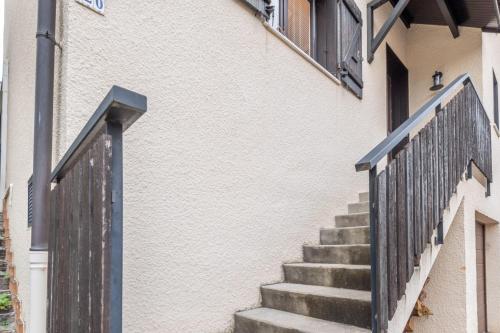 a set of stairs with a black railing next to a building at ALPILOC - Town house with garden and winter lounge in Annecy