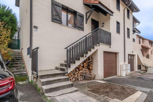 a house with stairs and a pile of fire wood at ALPILOC - Town house with garden and winter lounge in Annecy
