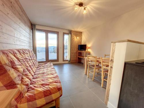 un salon avec un canapé et une table dans l'établissement Studio confortable avec terrasse sud et retour ski - FR-1-275-206, à La Rosière