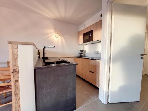 une petite cuisine avec un évier et un réfrigérateur dans l'établissement Studio confortable avec terrasse sud et retour ski - FR-1-275-206, à La Rosière