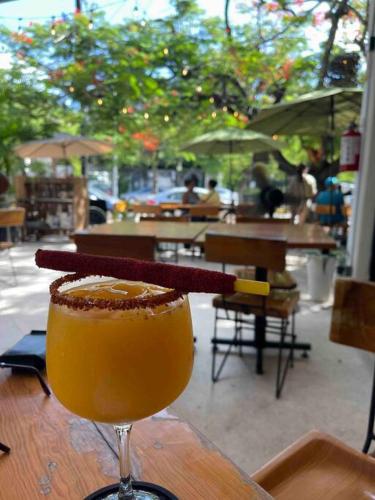 a drink is sitting on a wooden table at Casa Cebra by the beach -Roof top lounge! Playa del Niño in Cancún