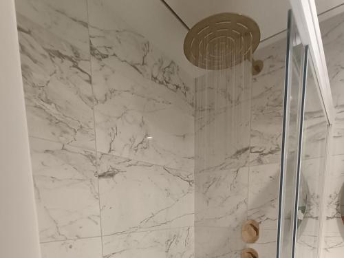 La salle de bains est pourvue d'une douche en marbre et d'une porte en verre. dans l'établissement St Julian's Mercury Tower 13th floor Luxury Apt 1302 in Tallest Tower in Malta, à San Ġiljan