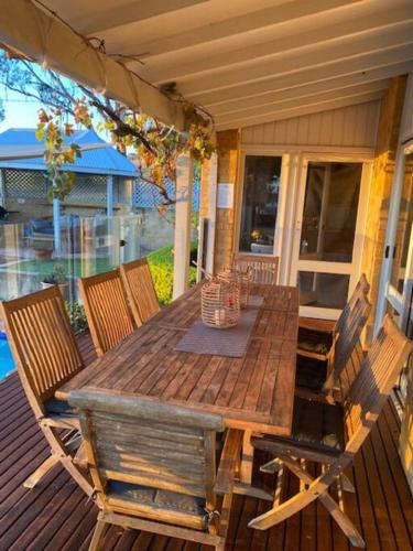 a wooden table and chairs on a porch at Milla's Vineyard Estate in Pokolbin