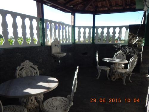 a porch with a table and chairs and windows at Pousada Balbino in Cabo Frio