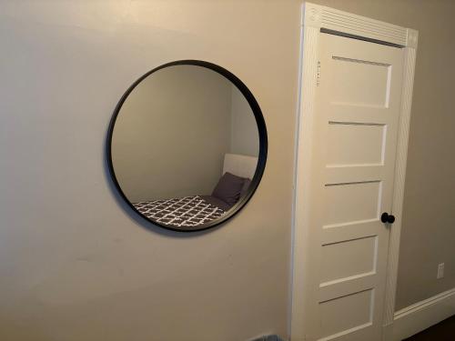 a round mirror on a wall next to a door at HomeStay B&B in Boston - 3 locations in Dorchester in Boston