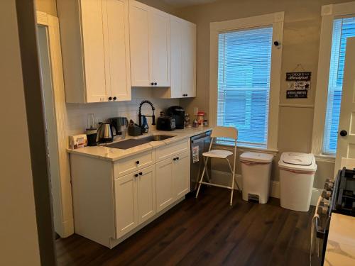 a kitchen with white cabinets and a sink at HomeStay B&B in Boston - 3 locations in Dorchester in Boston