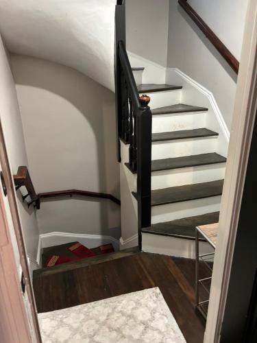 a stairway with a black and white stair case at HomeStay B&B in Boston - 3 locations in Dorchester in Boston