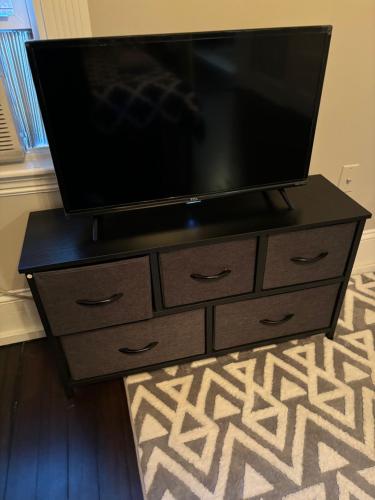 a flat screen tv on a dresser with a television on it at HomeStay B&B in Boston - 3 locations in Dorchester in Boston