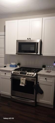 a kitchen with a stove and a microwave at HomeStay B&B in Boston - 3 locations in Dorchester in Boston