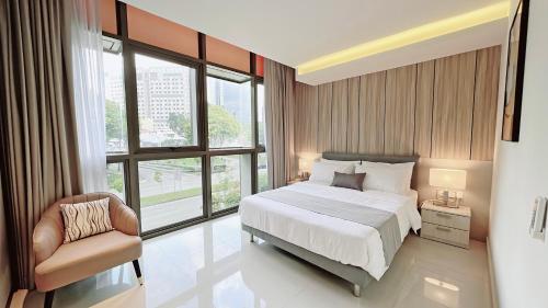 シンガポールにあるMoulmein Studios by K&C Serviced Apartmentのベッドルーム1室(ベッド1台、椅子、窓付)