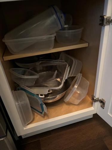 a cupboard with bowls and other items in it at HomeStay B&B in Boston - 3 locations in Dorchester in Boston