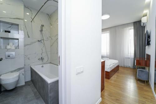a bathroom with a tub and a toilet and a sink at Hotel type rooms on avenue Melikishvili, city center in Tbilisi City
