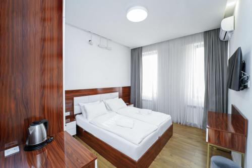 a bedroom with a white bed and a television at Hotel type rooms on avenue Melikishvili, city center in Tbilisi City