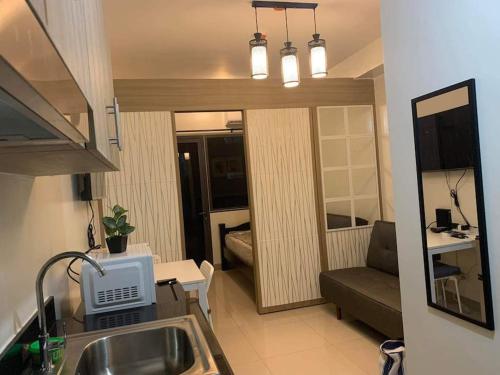 a kitchen with a sink and a living room at Shore Residence D22 shortwalk MOA Balconypoolview in Manila
