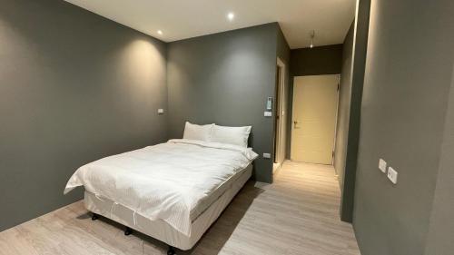 a small bedroom with a bed and a hallway at 私美宅居 in Zhushan