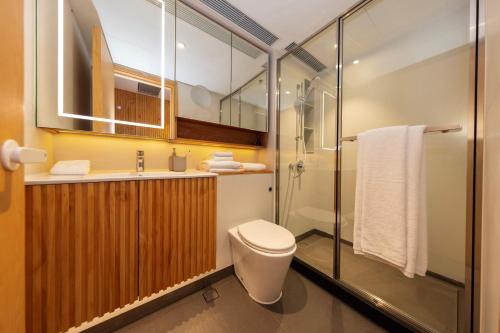 a bathroom with a toilet and a sink and a shower at Shama Hub Metro South Hong Kong in Hong Kong