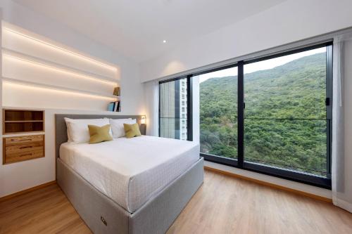 a bedroom with a bed and large windows at Shama Hub Metro South Hong Kong in Hong Kong