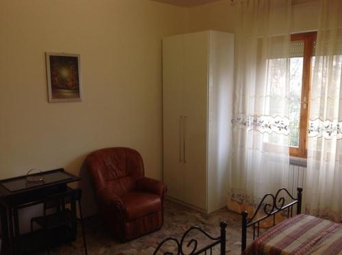 a living room with a chair and a window at Il Giardino del Gallo in Foligno