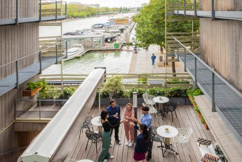 a group of people standing on a deck overlooking a river at Holiday Inn Express Paris-Canal De La Villette by IHG in Paris