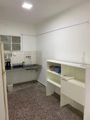 cocina con armarios blancos y encimera en Departamento Centro en Concepción del Uruguay