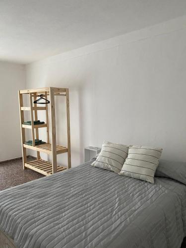 1 dormitorio con cama y estante de madera en Departamento Centro en Concepción del Uruguay