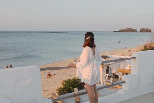 a woman in a white dress looking at the beach at Chiu Chiu Resort Đảo Phú Quý in Cu Lao Thu