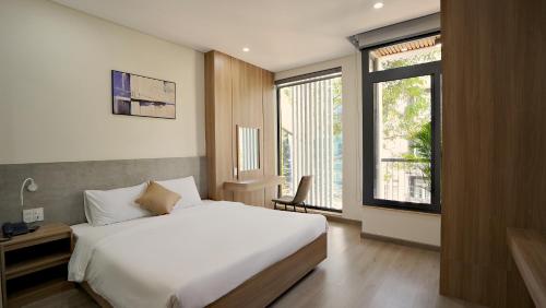 a bedroom with a bed and a large window at Thành Thuý Hotel in Buon Ma Thuot