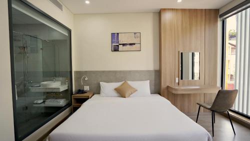 a bedroom with a bed and a sink and a mirror at Thành Thuý Hotel in Buon Ma Thuot
