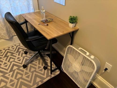 a wooden desk with a chair and a fan at HomeStay B&B in Boston - 3 locations in Dorchester in Boston