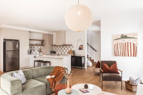 a living room with a couch and a kitchen at Architect Home with View in Central Hobart in Hobart