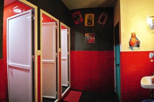 baño con paredes rojas y negras y lavabo en Sevilla Kitsch Hostel Art, en Sevilla