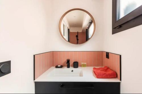 une salle de bain avec un lavabo blanc et un miroir dans l'établissement Aux portes du Panier, à Marseille