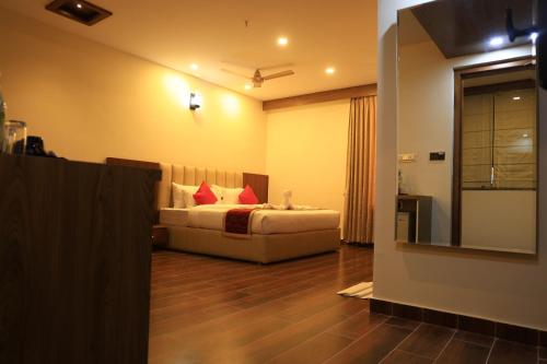 a bedroom with a bed with red pillows on it at Hotel Anand Grand in Hosūr