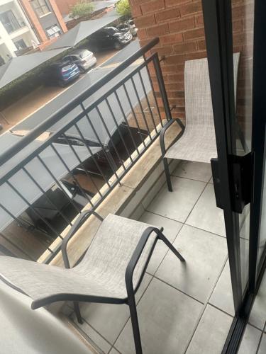 two chairs sitting on top of a balcony at One Bedroom The Blyde in Pretoria