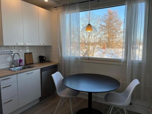 a kitchen with a table and chairs and a window at Kustaan neliö in Kokkola