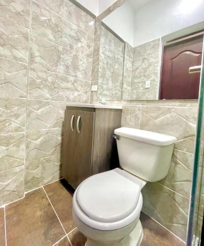 a bathroom with a white toilet in a room at Montesori Habitaciones estrato 6 atrás del CC campanario in Popayan