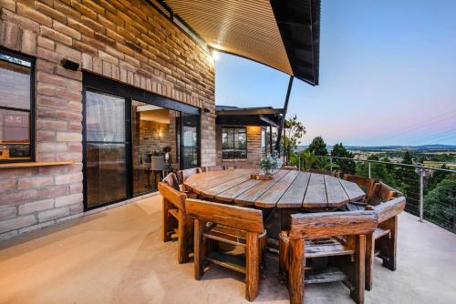 a dining room with a wooden table and chairs at 'Tyalla Lodge' Unique Luxe Design in the Mountains in Mudgee