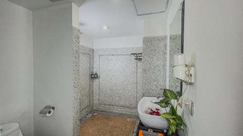 a white bathroom with a sink and a shower at Dusit Hotel Siem Reap in Siem Reap