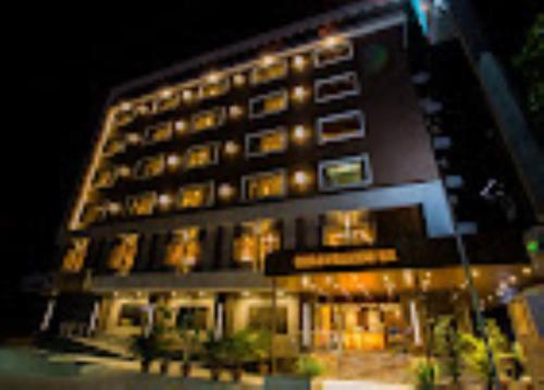 a tall building with many windows at night at Hotel Bhagyalaxmi , Shirdi in Shirdi